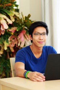 Young asian student studying at laptop