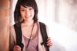 Happy female student with backpack thinking about college