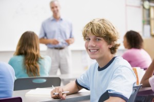 Male Student With Other Students In Classroom